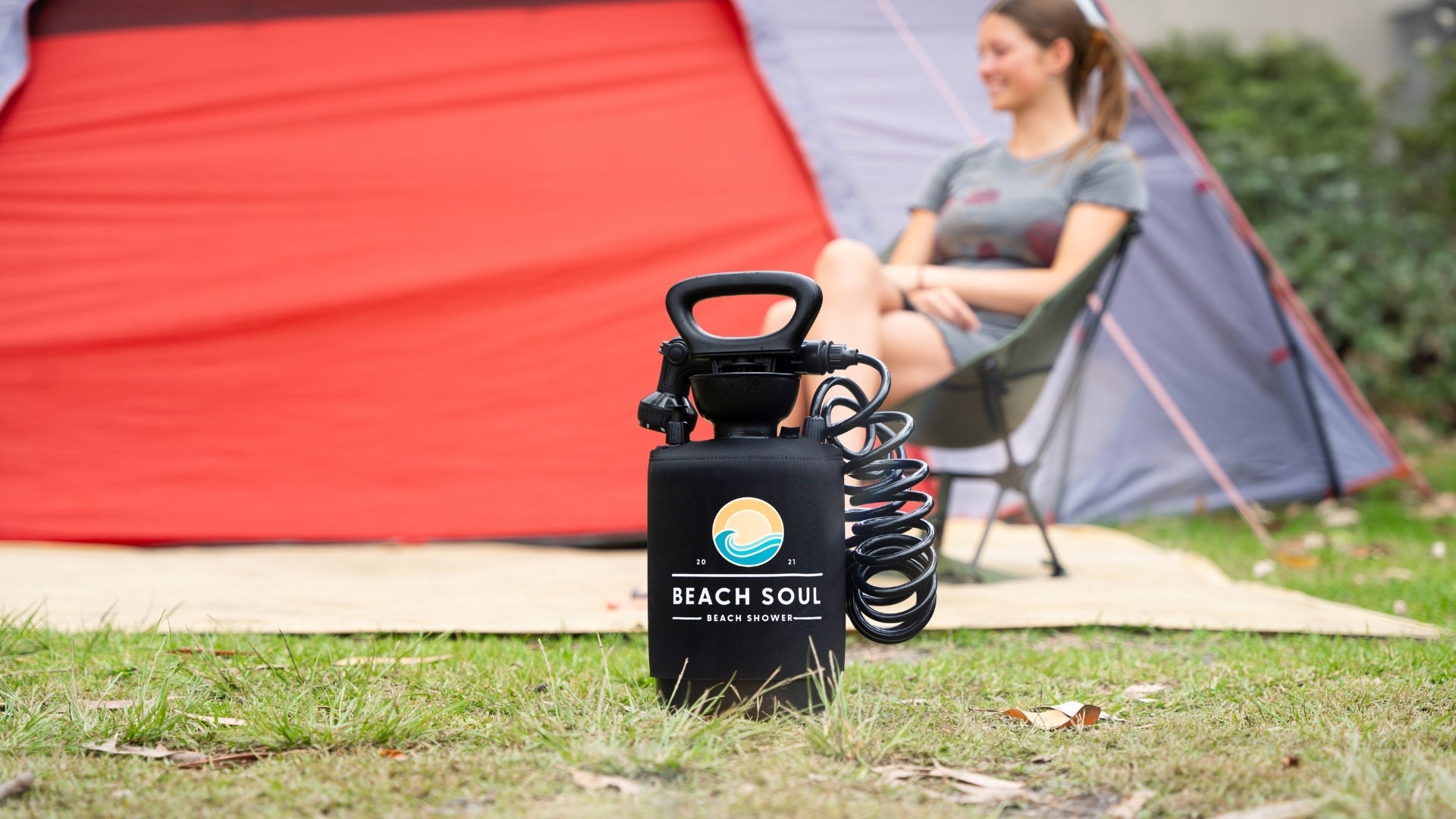 Beach Soul portable shower set up beside a tent at a campsite