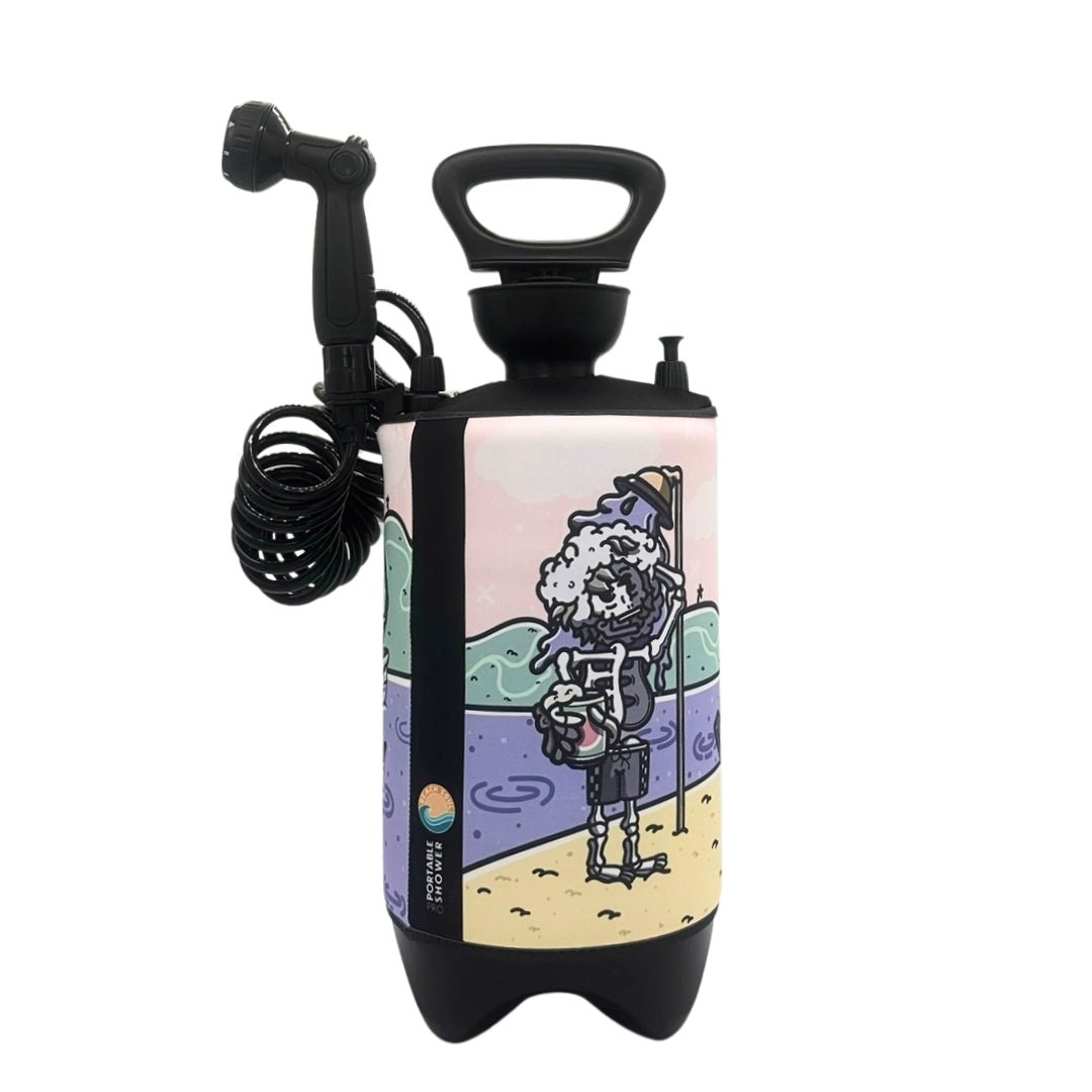 Black portable shower with coiled hose and nozzle featuring a colorful cartoon illustration of a skeleton with a rubber duck on its head holding a yellow bucket and showering on a pastel pink, green, and purple beach scene