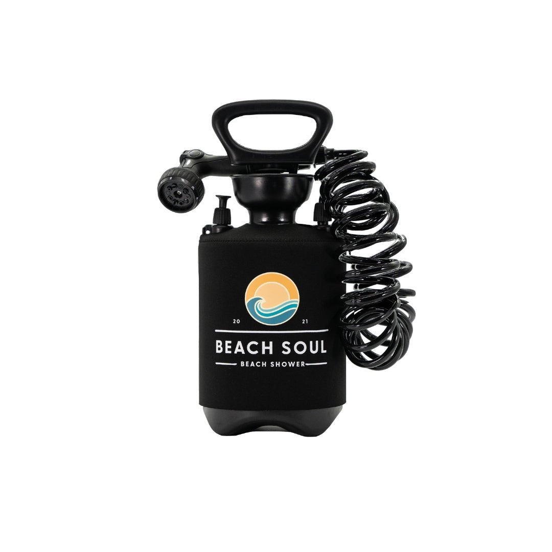 Black Beach Soul portable beach shower unit with a coiled hose, spray nozzle, and a branded neoprene sleeve displaying an orange sun and blue wave logo with the year 2021