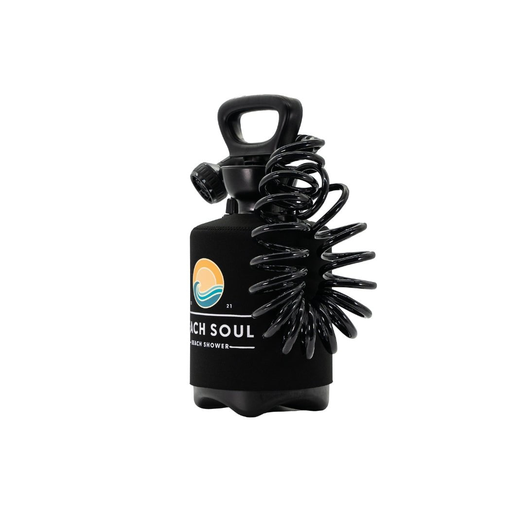 A black portable Beach Soul shower bottle on a white background featuring a yellow sun and blue wave logo and a coiled black hose