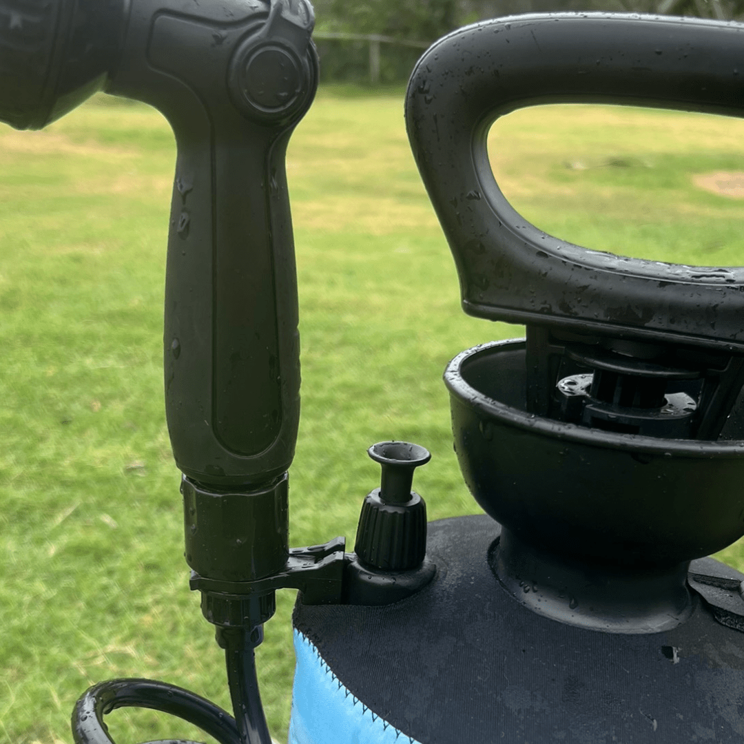 Close-up of a Beach Soul shower head secured to the portable shower tank with the Tank Clip