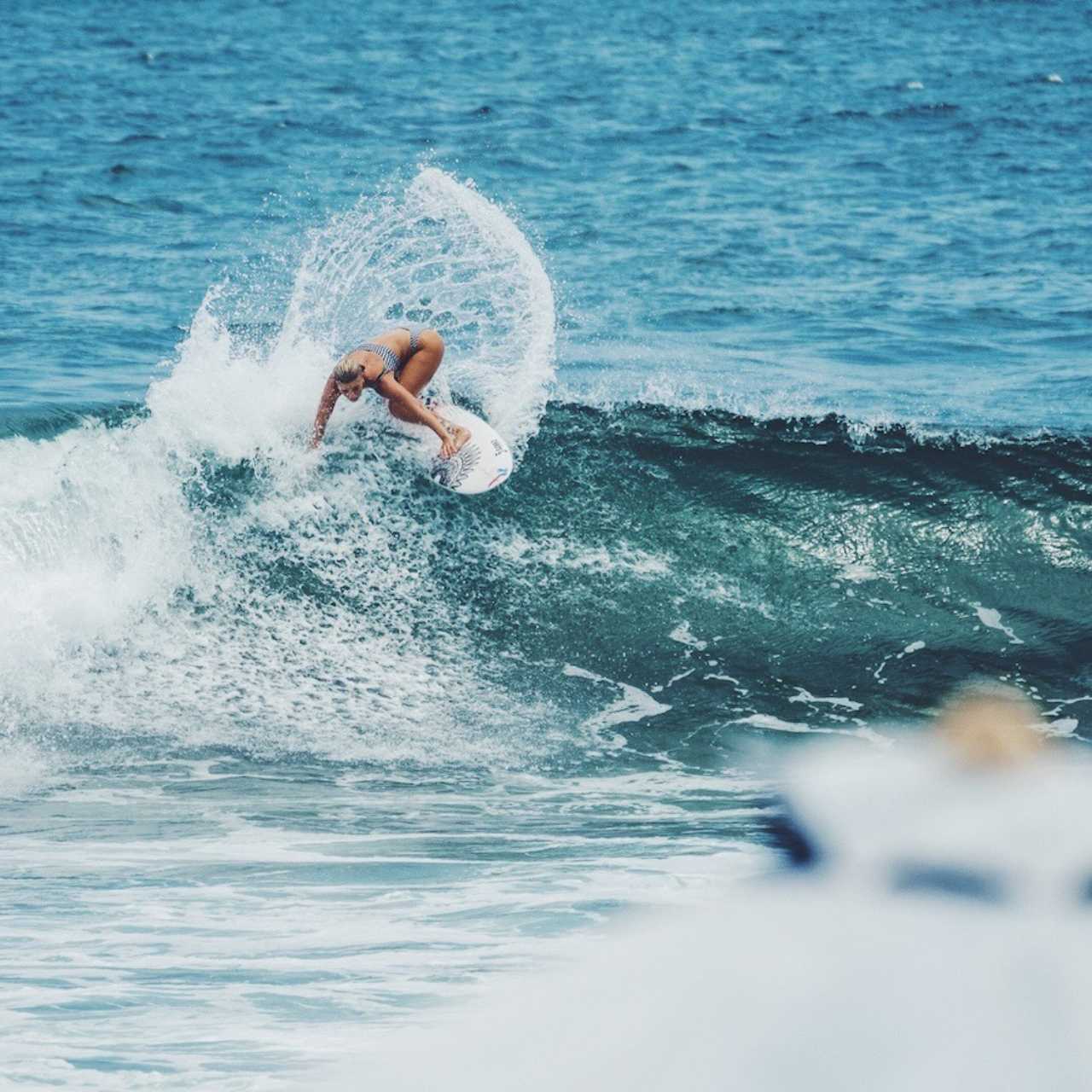 Surfer carving across a wave