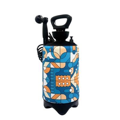 Product photo of a portable pressure shower featuring a vibrant blue, orange, and cream geometric abstract pattern on its body, with a black top handle and showerhead against a white background