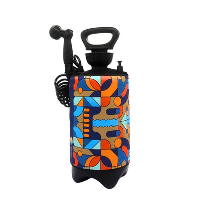 A portable shower bottle featuring a vibrant abstract geometric pattern sleeve in blues oranges and browns a black handle coiled hose and shower head with a small FLOSSOM logo isolated on a white background