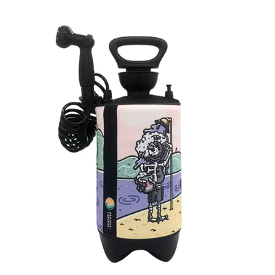 Black portable shower with coiled hose and nozzle featuring a colorful cartoon illustration of a skeleton with a rubber duck on its head holding a yellow bucket and showering on a pastel pink, green, and purple beach scene