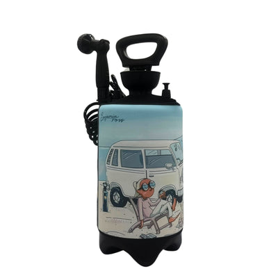 Portable shower unit by Benjamin Ross featuring a cartoon illustration of a white Volkswagen Kombi van on a sandy beach with two figures lounging in chairs, one wearing vibrant orange goggles under a light blue sky