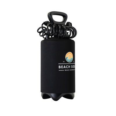 Digital photograph of a black Beach Soul portable beach shower featuring a coiled hose and carry handle, a distinctive orange sun and blue wave logo, and a sturdy three-lobed base