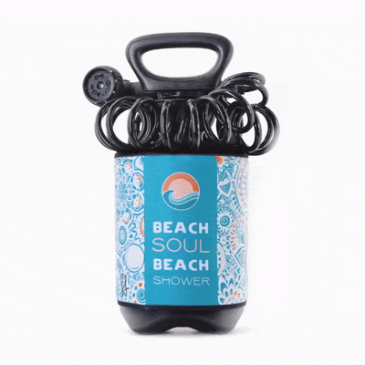 Product image of a Beach Soul Beach Shower featuring a blue label with an orange and white wave logo, intricate white and light blue mandala patterns, and a black coiled hose and sprayer with a handle