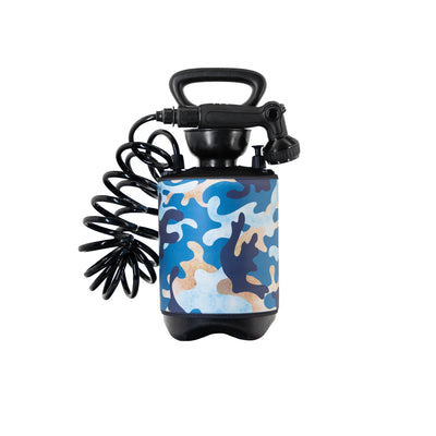 A portable pressure sprayer with a blue, tan, and dark blue camouflage patterned tank, black coiled hose, black handle, and shower spray nozzle on a white background