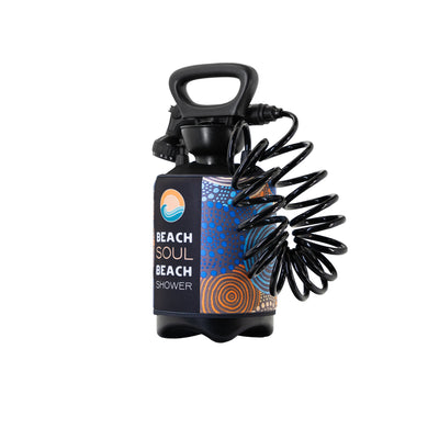 Product photo of a black Beach Soul Beach Shower portable shower unit featuring a top handle, coiled hose, and a colorful branded sleeve with "Beach Soul Beach Shower" text and abstract blue dot and orange concentric circle Indigenous-inspired patterns