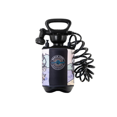 A portable black Beach Soul Beach Shower features a coiled hose and a colorful neoprene sleeve decorated with cartoon skeletons surfing and fishing alongside a circular sun and wave logo
