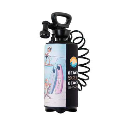 Digital product photo of a Beach Soul portable beach shower featuring a black handle, a coiled black hose, and a neoprene sleeve decorated with a colorful cartoon beach scene of surfers and two surfboards including a pink one with a lightning bolt, alongside a black panel displaying the brand name and a sun and wave logo
